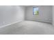 Neutral-toned bedroom features new carpet, fresh paint, natural light, and outdoor views at 7930 Alkire St, Arvada, CO 80005