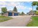 View of detached garage and a paved driveway leading up to the home with nice landscaping around at 7930 Alkire St, Arvada, CO 80005