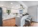 Renovated kitchen with a breakfast bar, pendant lighting, white cabinets, stainless steel appliances, and hardwood floors at 7930 Alkire St, Arvada, CO 80005