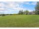 Expansive grassy yard with mature trees and a view of the house at 7930 Alkire St, Arvada, CO 80005