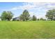 Wide open green yard with mature trees surrounding a single-Gathering home at 7930 Alkire St, Arvada, CO 80005