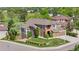 Beautifully landscaped home with manicured lawn, mature trees, and charming architectural details at 8922 S Tuscany Ln, Highlands Ranch, CO 80130