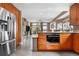 Open-concept kitchen with stainless steel appliances, wooden cabinets, and seamless flow into the living area with fireplace at 8922 S Tuscany Ln, Highlands Ranch, CO 80130