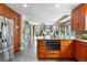 A modern kitchen boasts wood cabinets, an island with a built-in oven, and an open view to the living room at 8922 S Tuscany Ln, Highlands Ranch, CO 80130