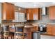 Well-appointed kitchen with custom wood cabinets, granite countertops, stainless steel appliances, and breakfast bar seating at 8922 S Tuscany Ln, Highlands Ranch, CO 80130
