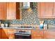 Detailed shot of a kitchen featuring wooden cabinets, tile backsplash and stainless appliances at 8922 S Tuscany Ln, Highlands Ranch, CO 80130