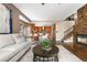 Open-concept living room with a stone fireplace, wooden flooring, and staircase at 8922 S Tuscany Ln, Highlands Ranch, CO 80130