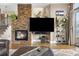 Living area with stone fireplace and large screen TV, steps to stairs and outdoor access at 8922 S Tuscany Ln, Highlands Ranch, CO 80130