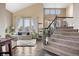 Inviting living area with high ceilings, large windows, and a view of the open staircase at 8922 S Tuscany Ln, Highlands Ranch, CO 80130
