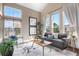 Sunlit living room with stylish furniture, modern artwork, and large windows offering scenic views at 8922 S Tuscany Ln, Highlands Ranch, CO 80130