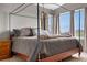 Primary bedroom with neutral gray walls, canopy bed, and a view from the window at 8922 S Tuscany Ln, Highlands Ranch, CO 80130