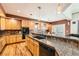 Spacious kitchen featuring granite countertops, wood cabinetry, stainless steel appliances, and hardwood floors at 333 Mesa St, Brighton, CO 80601