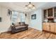 Cozy sitting room features hardwood floors, a stylish light fixture, and a comfortable loveseat at 333 Mesa St, Brighton, CO 80601