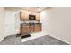 Charming wet bar with sink, granite countertop, microwave, and wooden cabinets on carpet in finished basement at 333 Mesa St, Brighton, CO 80601
