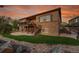 Backyard with a deck, patio, lush green grass and a stone accent wall at 27615 E Moraine Dr, Aurora, CO 80016