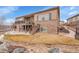 A two-story home with a stone facade, a tiered deck, and a meticulously landscaped backyard at 27615 E Moraine Dr, Aurora, CO 80016