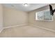A minimalist bedroom with neutral tones, carpet, and a window, complemented by a wall-mounted TV for entertainment at 27615 E Moraine Dr, Aurora, CO 80016