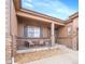 Cozy covered front porch features stone columns and comfortable seating area at 27615 E Moraine Dr, Aurora, CO 80016