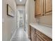 Hallway view showing tile floors, cabinets, and an open door leading to the bathroom at 27615 E Moraine Dr, Aurora, CO 80016