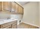 Laundry area with utility sink, cabinets, and hookups for washer and dryer at 27615 E Moraine Dr, Aurora, CO 80016