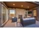 Covered outdoor living space with stone fireplace, TV and comfortable seating at 27615 E Moraine Dr, Aurora, CO 80016