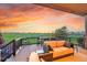 Spacious patio overlooking a green golf course with comfortable seating and a beautiful sunset view at 27615 E Moraine Dr, Aurora, CO 80016