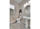 Bright powder room with pedestal sink, oval mirror, wood shelf, and window at 27615 E Moraine Dr, Aurora, CO 80016