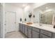 Stylish bathroom with gray cabinets, dual sinks, modern fixtures, and a glass-enclosed shower at 23936 E River Front Dr, Aurora, CO 80019