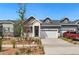 Charming home featuring white brick and gray siding with a two-car garage and manicured rock landscaping at 23936 E River Front Dr, Aurora, CO 80019