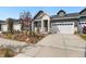 Charming home featuring white brick and gray siding with a two-car garage and walkway landscaping at 23936 E River Front Dr, Aurora, CO 80019
