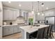 Stylish kitchen featuring white countertops, a central island with bar seating, and gray cabinetry at 23936 E River Front Dr, Aurora, CO 80019