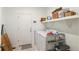 Functional laundry room equipped with a washer, dryer, shelving, and convenient storage solutions at 23936 E River Front Dr, Aurora, CO 80019