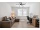 Comfortable living room featuring a leather couch and a large window, creating a warm and inviting atmosphere at 23936 E River Front Dr, Aurora, CO 80019