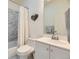 Compact bathroom with white vanity, toilet, and shower-tub combo featuring marble-style tiles, offering a clean design at 15649 E 7Th Cir, Aurora, CO 80011