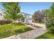 Attractive home featuring a well-maintained lawn, mature trees, and a two-car attached garage at 15649 E 7Th Cir, Aurora, CO 80011