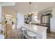 Well-lit kitchen with hardwood floors, gray cabinets, stainless appliances, and a modern kitchen island at 15649 E 7Th Cir, Aurora, CO 80011