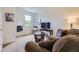 Inviting living room featuring a plush sofa, modern decor, and a window offering natural light, creating a cozy atmosphere at 15649 E 7Th Cir, Aurora, CO 80011
