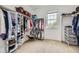 Spacious walk-in closet with custom shelving and ample storage solutions, illuminated by a natural light from a window at 15649 E 7Th Cir, Aurora, CO 80011