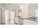 Bright primary bathroom with dual sinks, modern fixtures, and walk-in shower and adjoining room at 585 Twilight St, Erie, CO 80516