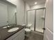 Bathroom featuring a glass shower, gray tile flooring, and a modern vanity at 585 Twilight St, Erie, CO 80516