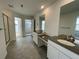 Modern bathroom with double sinks, white cabinetry, gray countertops, a tiled floor, and a separate shower, maximizing functionality at 585 Twilight St, Erie, CO 80516