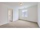 Neutral bedroom with a large window and an open doorway to another room at 585 Twilight St, Erie, CO 80516