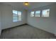 Bright bedroom featuring three windows, neutral carpet, and fresh, white paint at 585 Twilight St, Erie, CO 80516