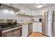 Updated kitchen with stainless steel appliances and white cabinetry at 1885 S Quebec Way # A14, Denver, CO 80231