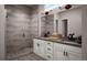 Elegant bathroom with double sinks, white cabinets, and a spacious walk-in shower with decorative tile at 1785 Grayside Cir, Castle Rock, CO 80109