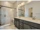 Bathroom with glass shower, shower bench, double sinks, and large mirror at 1785 Grayside Cir, Castle Rock, CO 80109