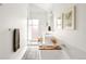 Bright, white bathroom features a soaking tub, sleek vanity, and glass enclosed shower with marble-style tile at 3422 S Grant St, Englewood, CO 80113