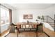 Bright dining room features a large wood table, modern decor, and an adjacent staircase with black metal railings at 3422 S Grant St, Englewood, CO 80113