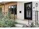 Close up of a modern home exterior with a striking black door and manicured landscaping at 3422 S Grant St, Englewood, CO 80113