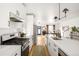 Bright open-concept kitchen boasts stainless appliances, white cabinets, and a large island with breakfast bar at 3422 S Grant St, Englewood, CO 80113